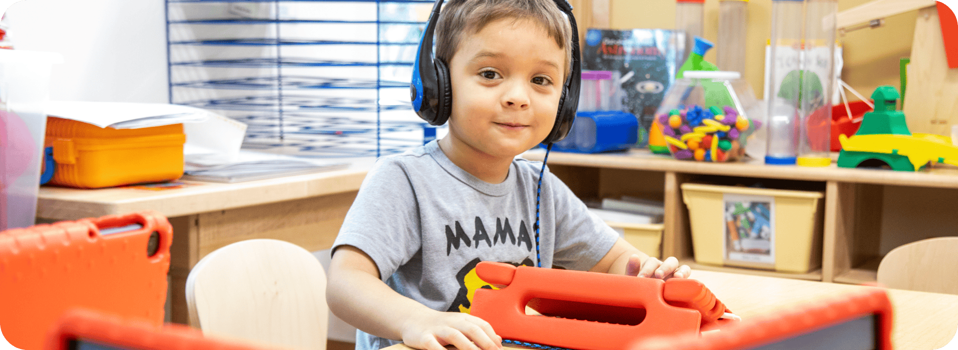 Young child with headphones engaging in classroom activity.
