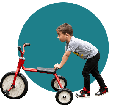 boy pushing a tricycle