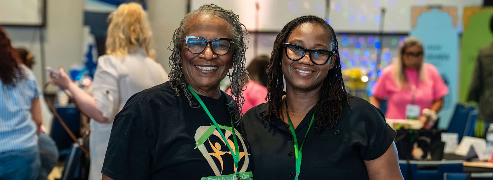 Two smiling women wearing black shirts and glasses at Provider: Provider Supports event.