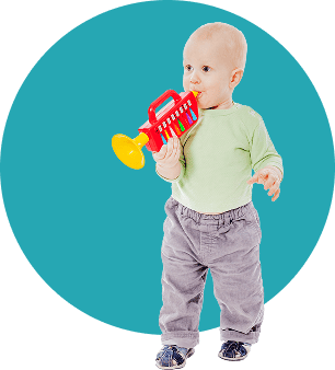 Baby playing with red and yellow toy trumpet on blue background.