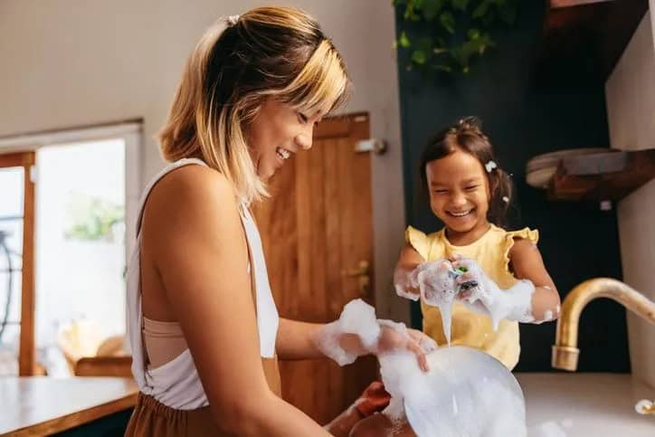 parent and child washing dishes