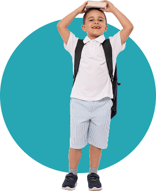 Young boy with backpack holding a book above his head, smiling.